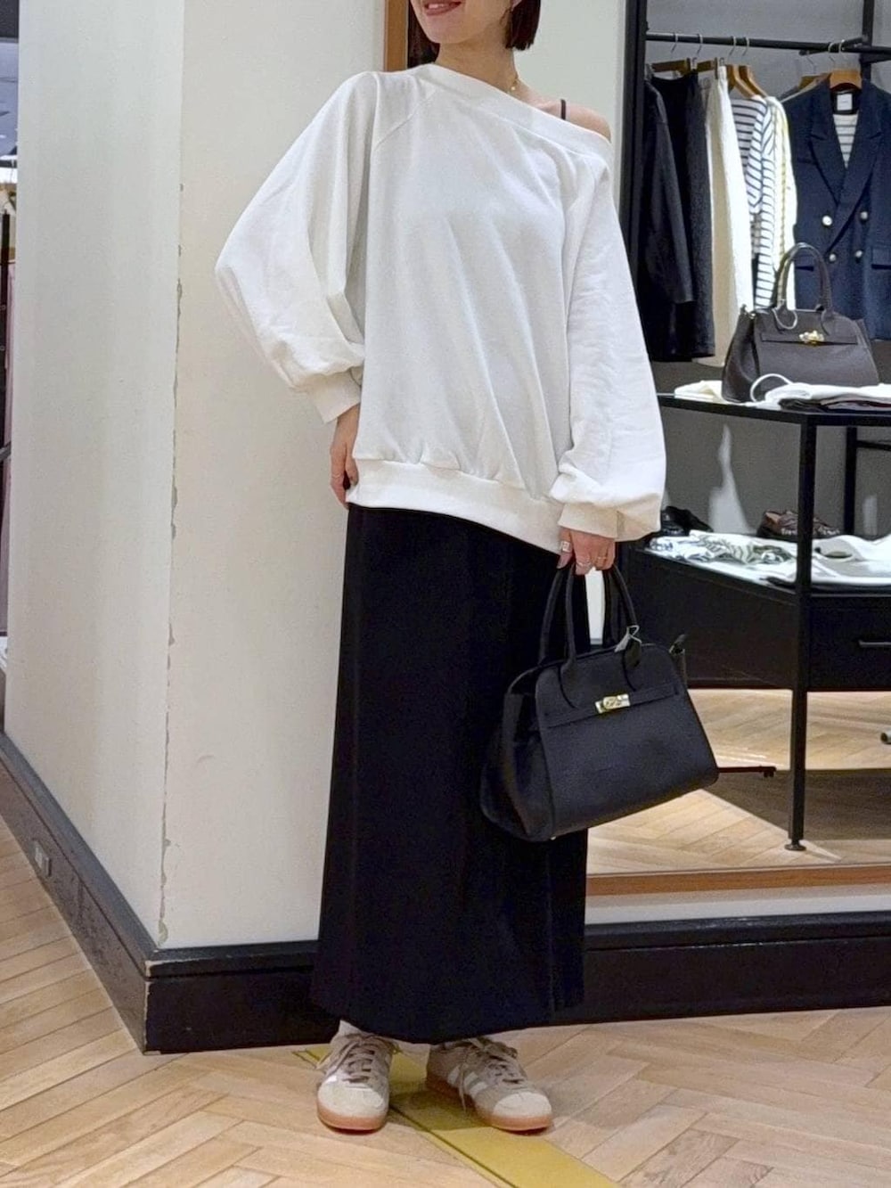 ベージュ系のスニーカー、ブラック系のショルダーバッグ、ホワイト系のスウェットを着用したレディースの冬コーディネートの5枚目の写真