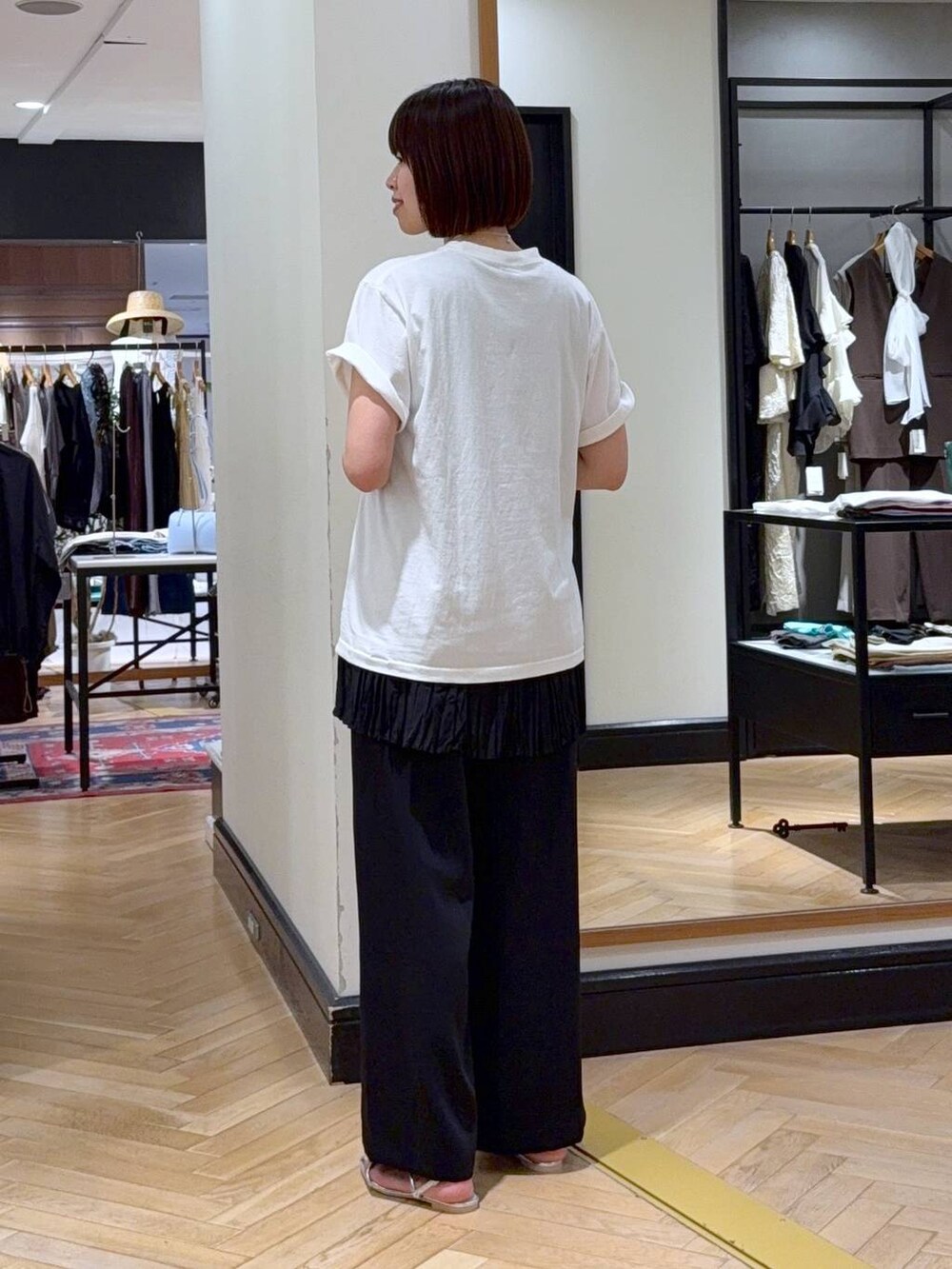 ホワイト系のTシャツ/カットソー、シルバー系のサンダル、ブラック系のハンドバッグを着用したレディースの夏コーディネートの3枚目の写真