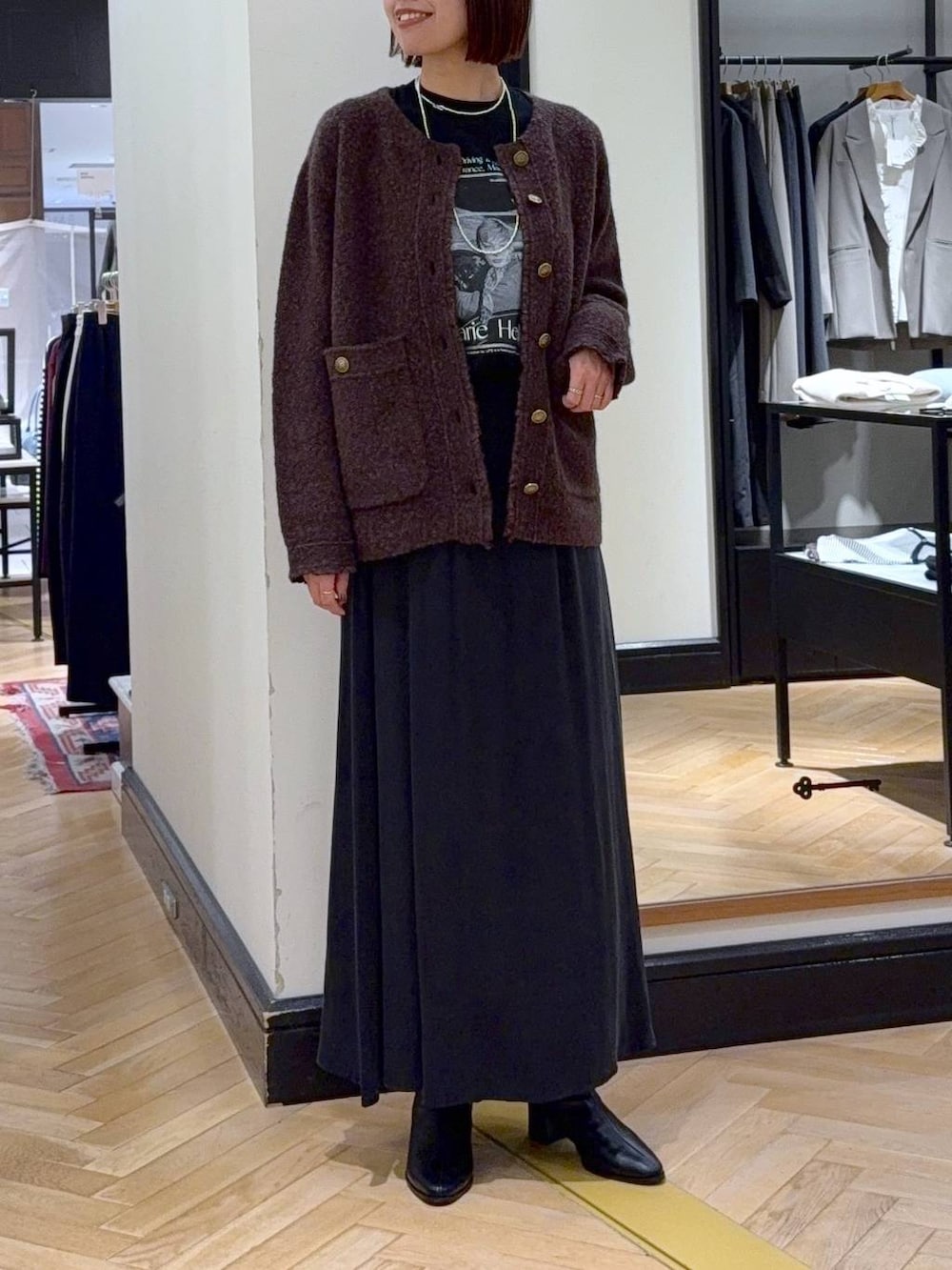 ブラック系のブーツ、ブラウン系のカーディガン/ボレロ、ブラック系のスカートを着用したレディースの秋コーディネートの2枚目の写真