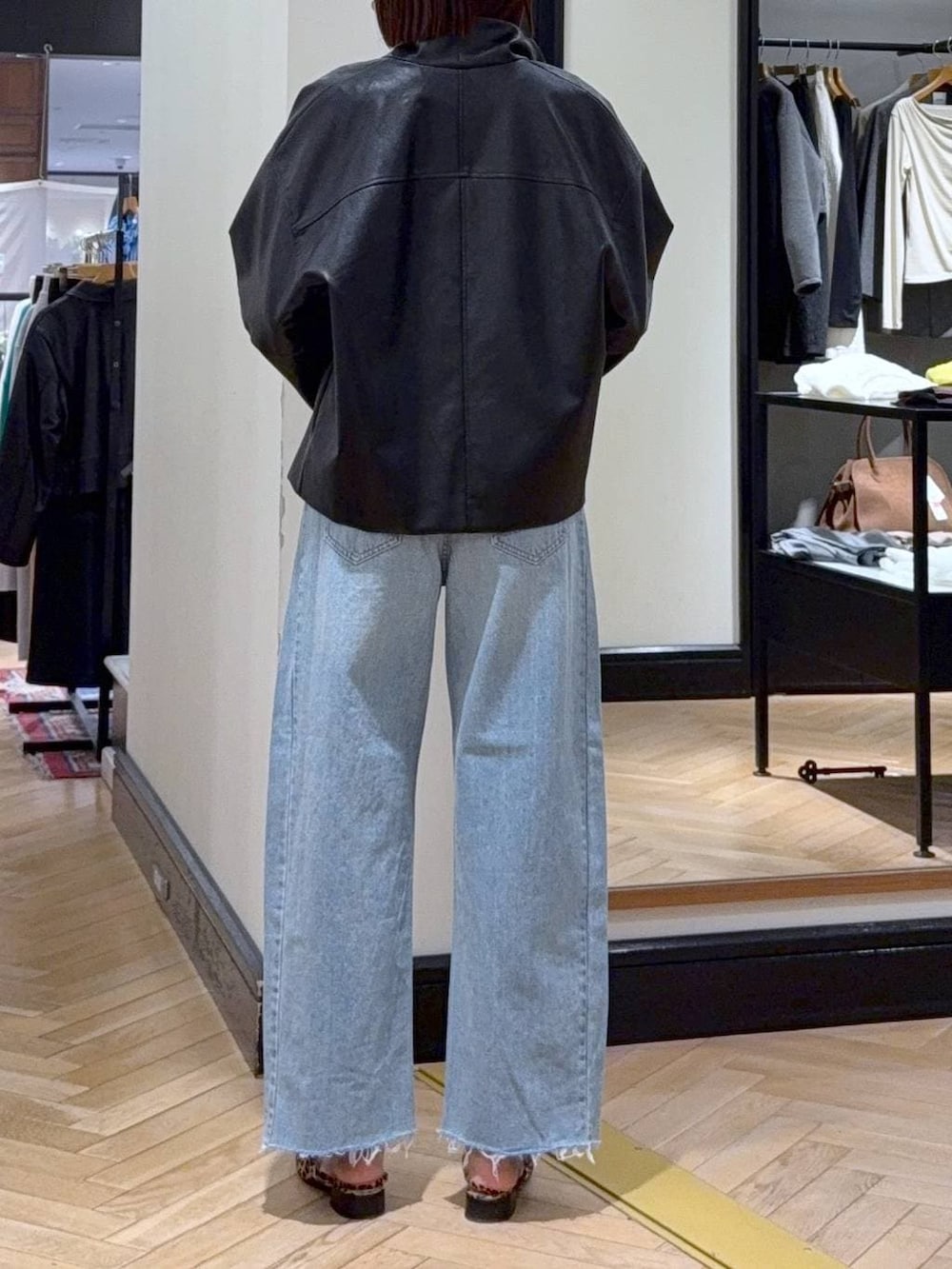 ブルー系のデニムパンツ、ブラック系のブルゾン、ブラウン系のパンプスを着用したレディースの春コーディネートの5枚目の写真