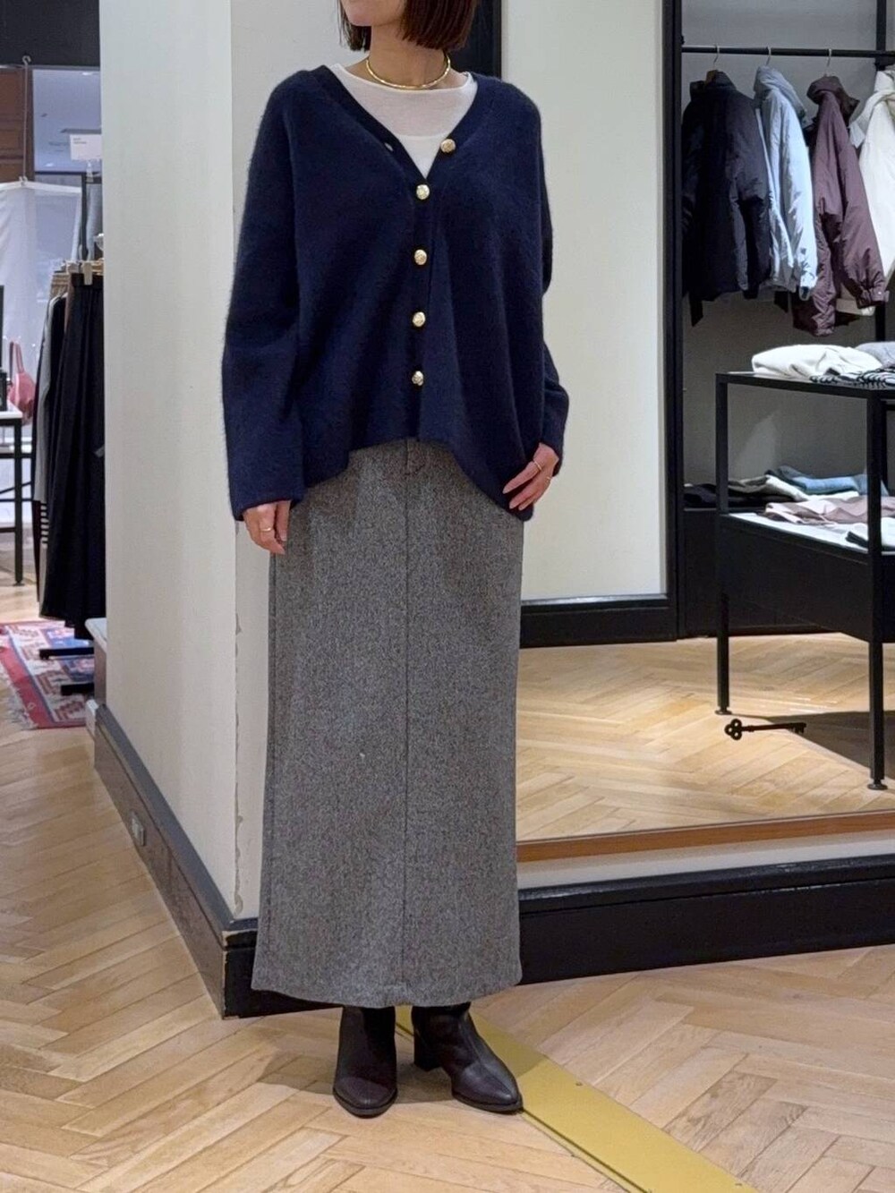 ブルー系のカーディガン/ボレロ、ホワイト系のTシャツ/カットソー、ブラック系のブーツを着用したレディースの秋コーディネートの2枚目の写真