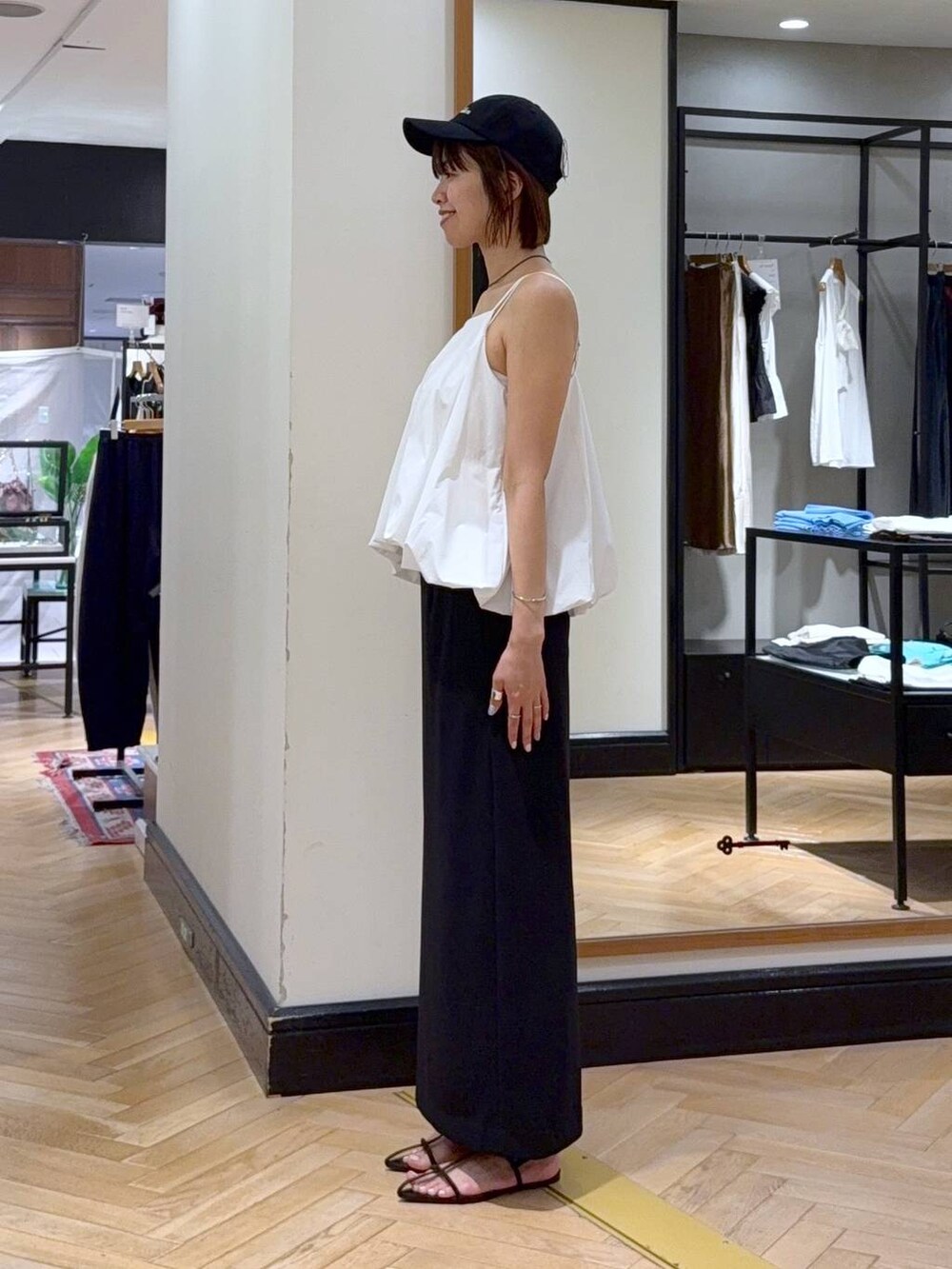 ブラウン系のサンダル、ホワイト系のセットアップ、ブラック系のショルダーバッグを着用したレディースの夏コーディネートの4枚目の写真