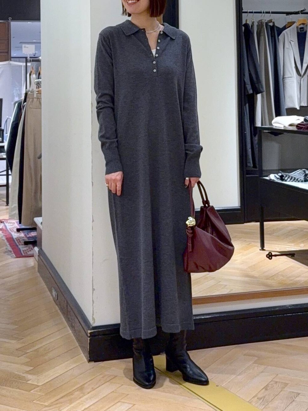 ブラック系のブーツ、ブラック系のショルダーバッグ、グレー系のワンピースを着用したレディースの秋コーディネートの6枚目の写真