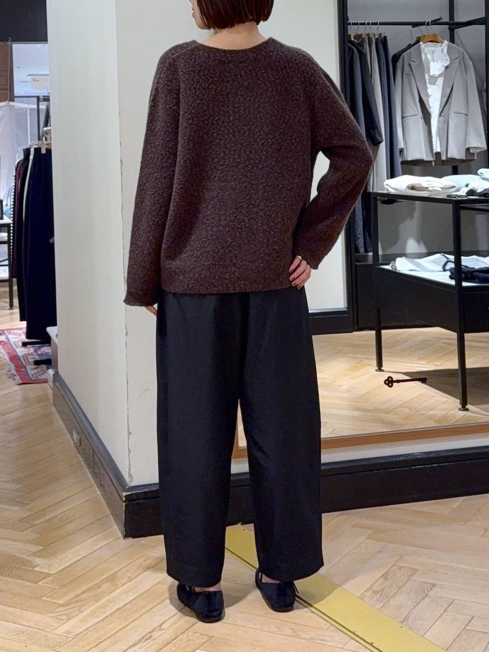 ブラック系のスラックス、ブラウン系のカーディガン/ボレロ、ブラック系のショルダーバッグを着用したレディースの秋コーディネートの4枚目の写真