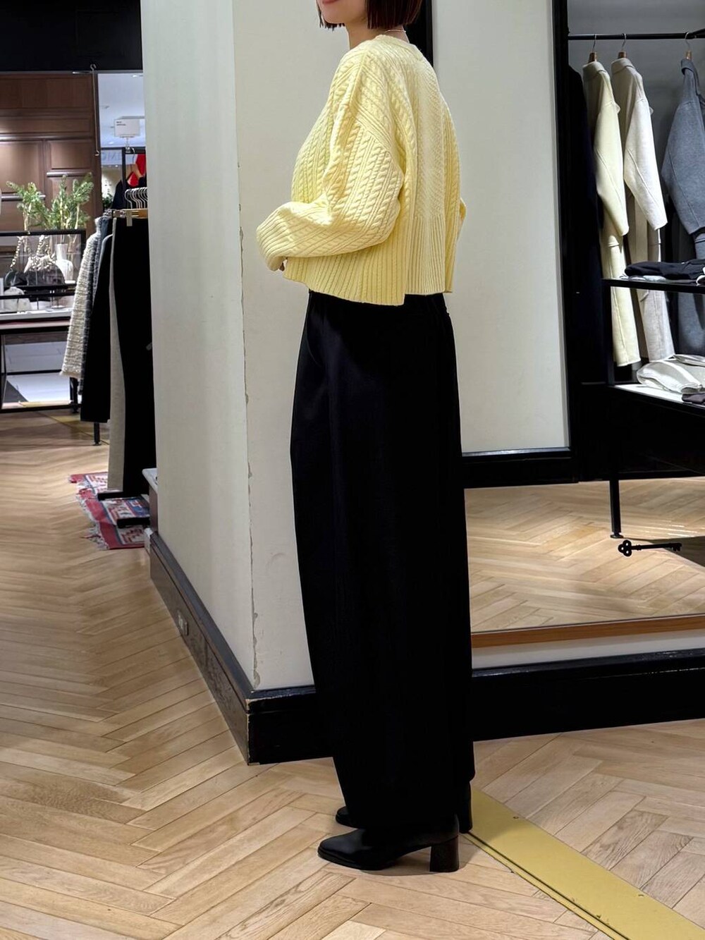 ブラック系のスラックス、ブラック系のブーツ、ブラック系のショルダーバッグを着用したレディースの冬コーディネートの3枚目の写真