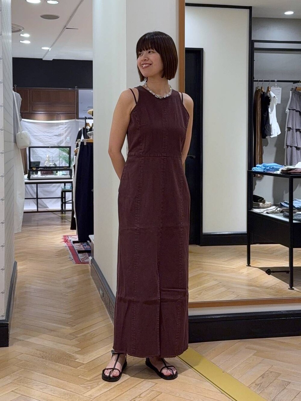 シルバー系のハンドバッグ、レッド系のワンピース、ホワイト系のサンダルを着用したレディースの夏コーディネートの6枚目の写真