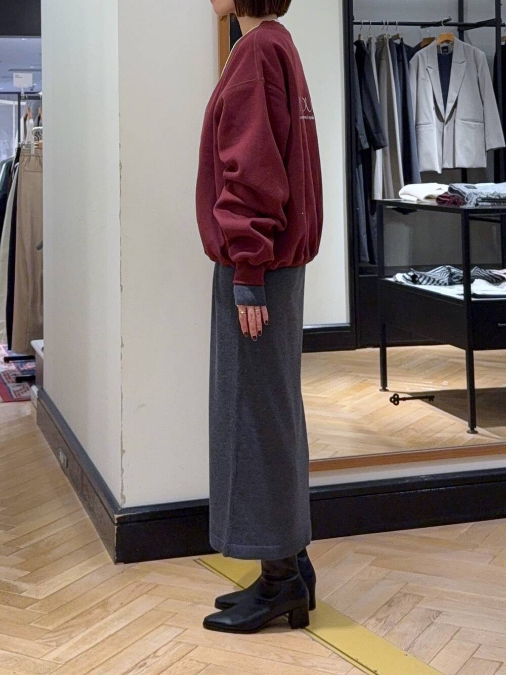 ブラック系のブーツ、ブラック系のショルダーバッグ、グレー系のワンピースを着用したレディースの秋コーディネートの2枚目の写真