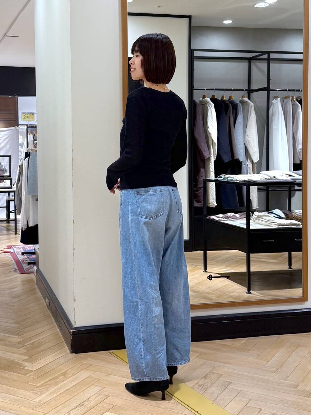 ブルー系のデニムパンツ、ブラック系のブーツ、ブラック系のカーディガン/ボレロを着用したレディースの秋コーディネートの3枚目の写真