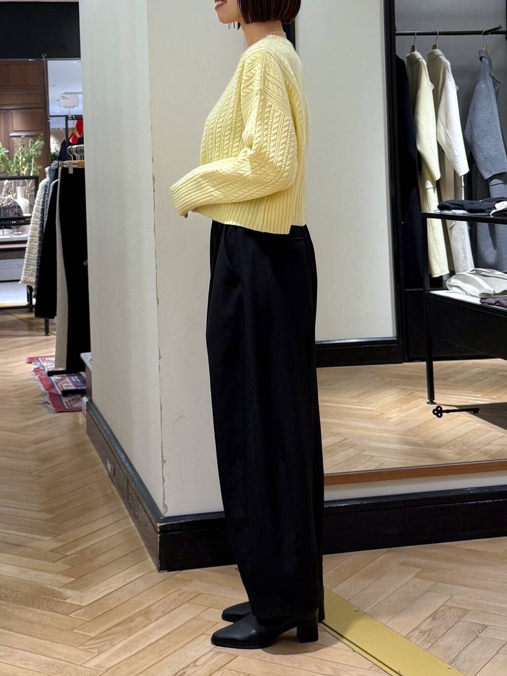 ブラック系のスラックス、ブラック系のブーツ、ブラック系のショルダーバッグを着用したレディースの冬コーディネートの2枚目の写真