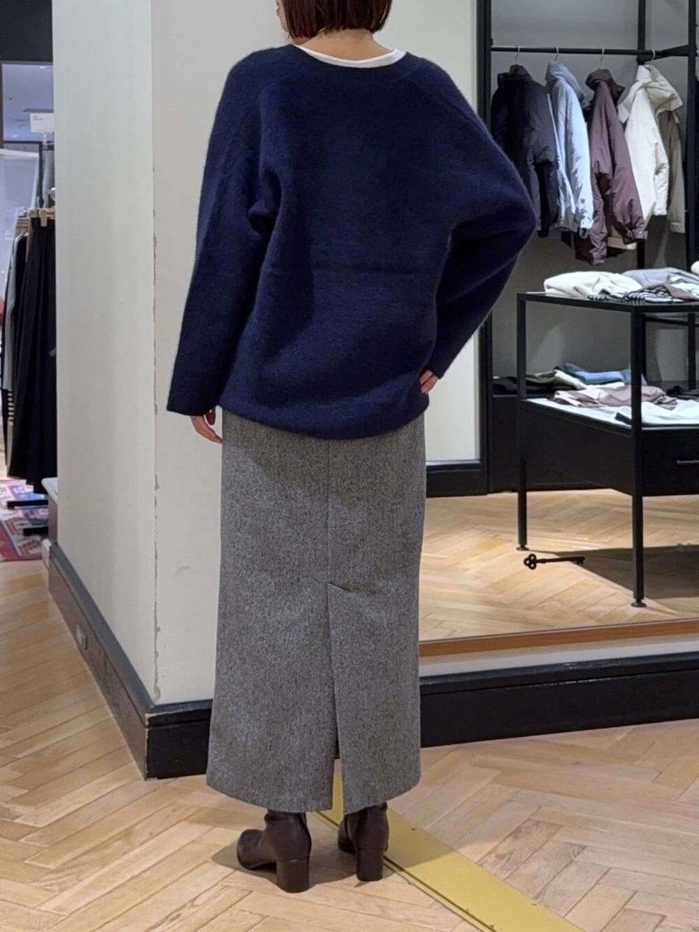 ブルー系のカーディガン/ボレロ、ホワイト系のTシャツ/カットソー、ブラック系のブーツを着用したレディースの秋コーディネートの5枚目の写真