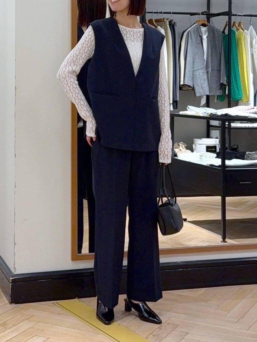 ホワイト系のTシャツ/カットソー、ブルー系のスーツセット、ブラック系のショルダーバッグを着用したレディースの冬コーディネートの2枚目の写真