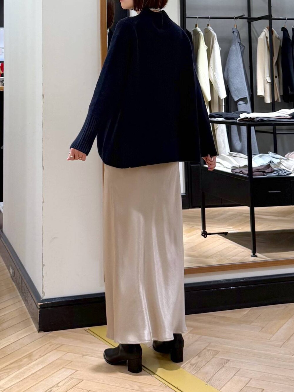 ブラック系のブーツ、ブルー系のニット/セーター、ベージュ系のスカートを着用したレディースの冬コーディネートの5枚目の写真