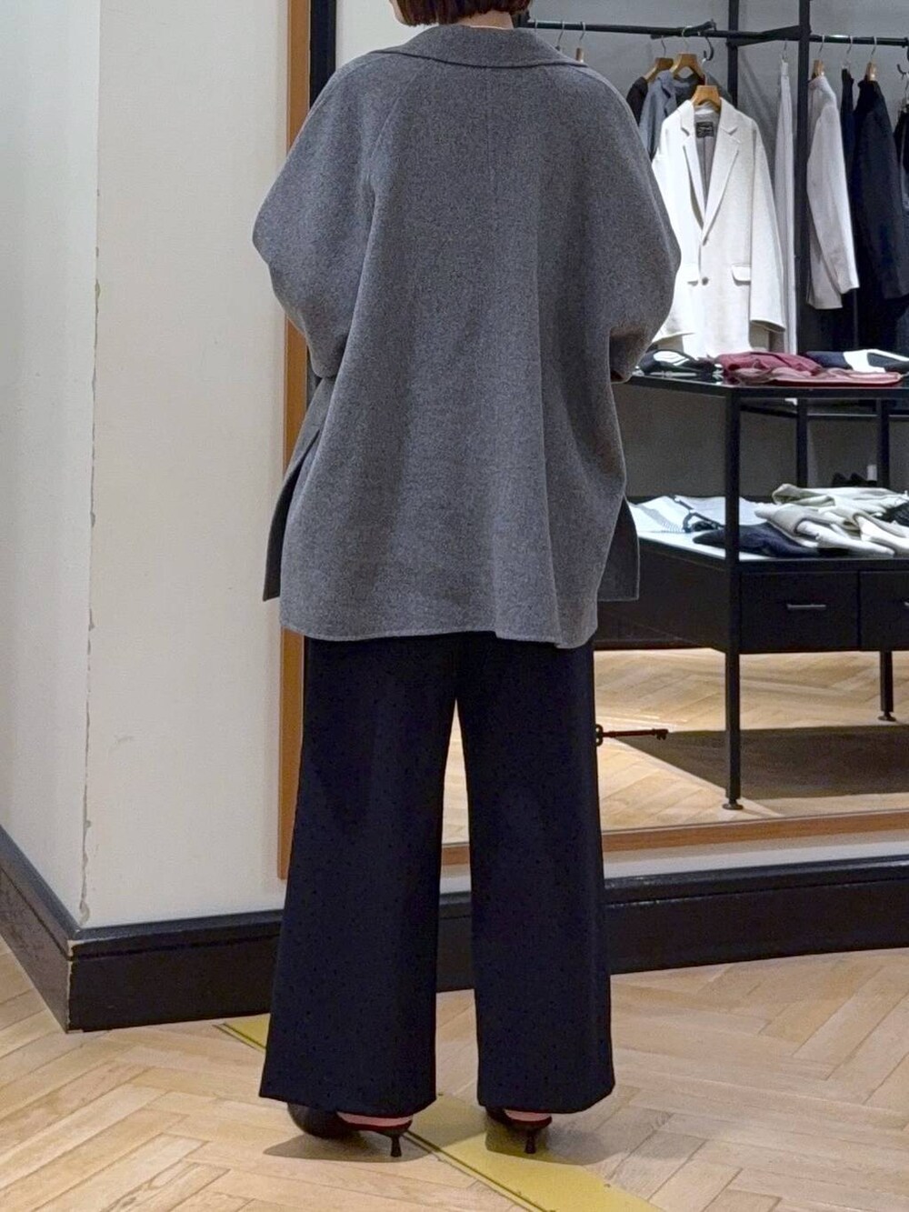 グレー系のその他アウター、ホワイト系のニット/セーター、ブラック系のスラックスを着用したレディースの秋コーディネートの7枚目の写真