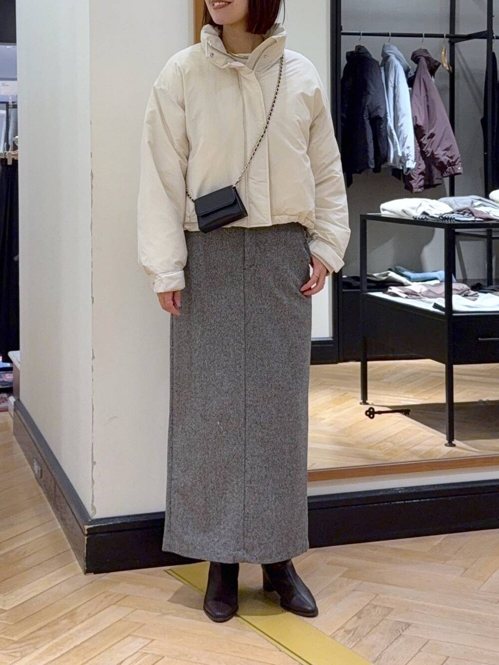 ブラウン系のブーツ、ホワイト系のブルゾン、ブラック系のスカートを着用したレディースの秋コーディネートの4枚目の写真