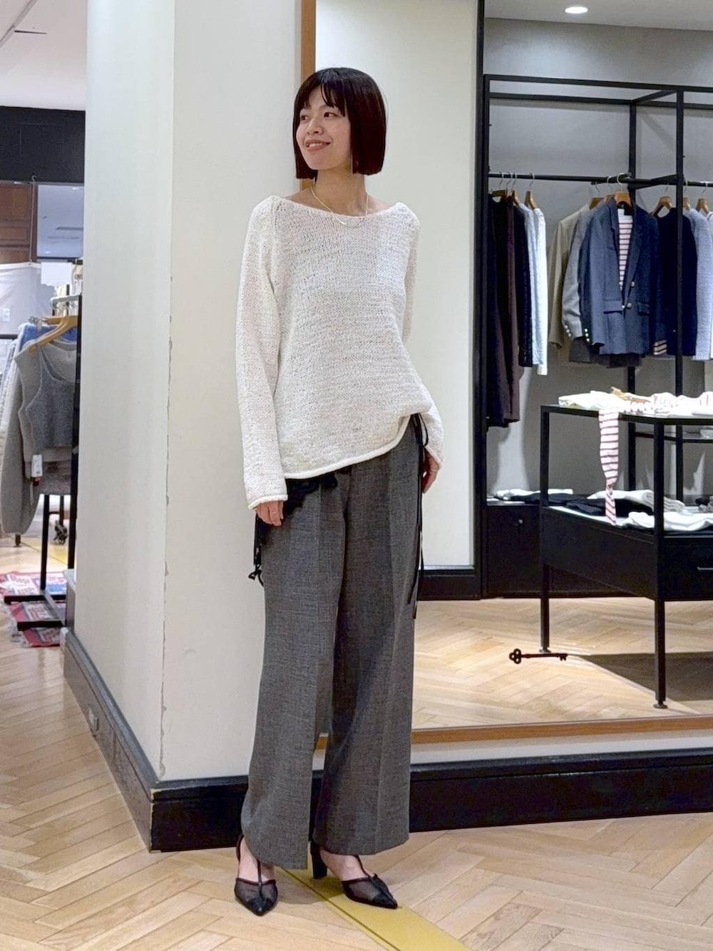 グリーン系のショルダーバッグ、ブラック系のスラックス、ブラック系のパンプスを着用したレディースの冬コーディネートの5枚目の写真