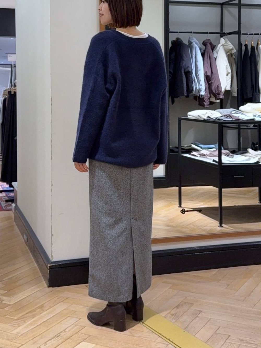 ブルー系のカーディガン/ボレロ、ホワイト系のTシャツ/カットソー、ブラック系のブーツを着用したレディースの秋コーディネートの4枚目の写真