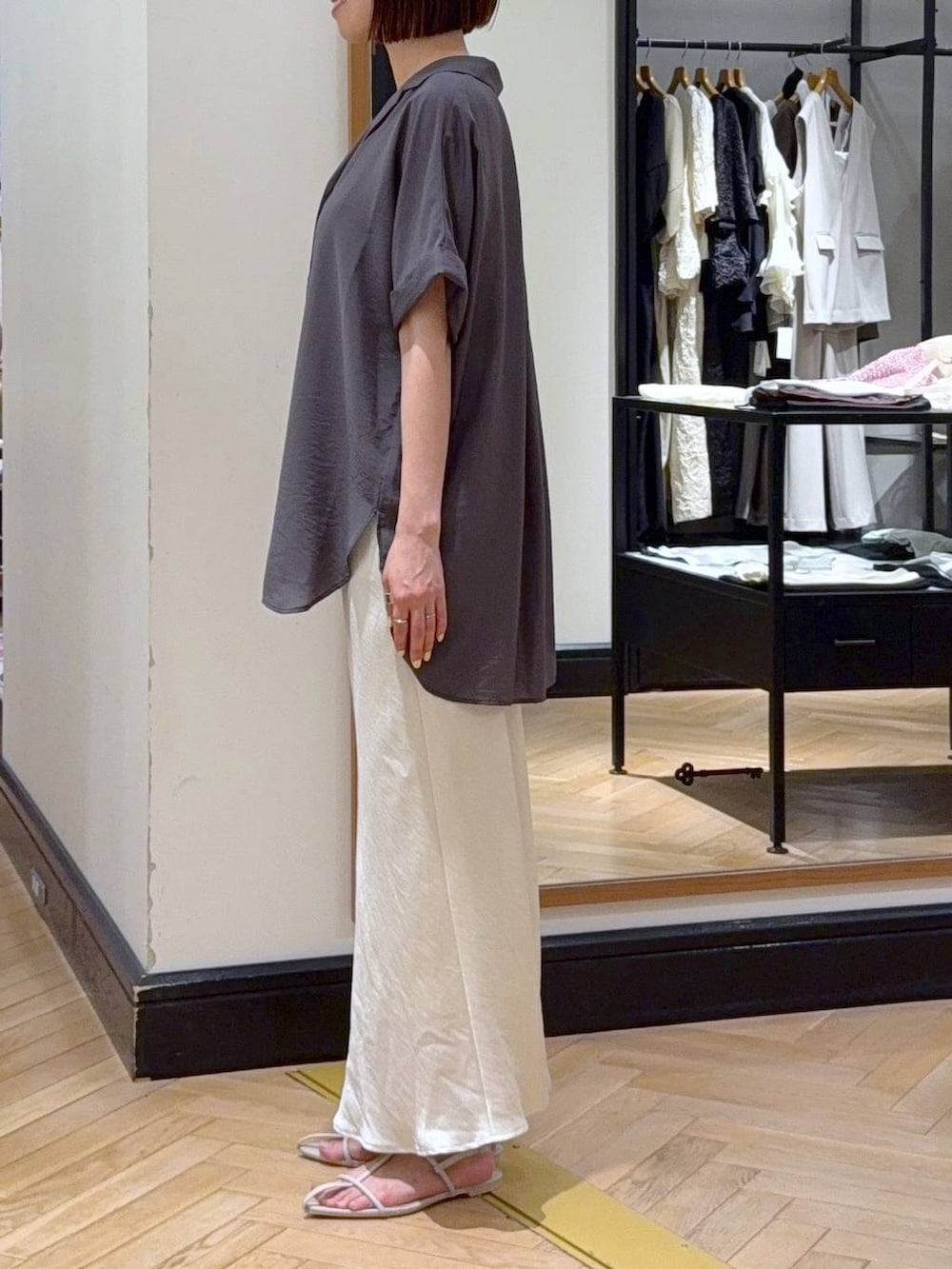 ホワイト系のスカート、ホワイト系のサンダル、グレー系のシャツ/ブラウスを着用したレディースの夏コーディネートの3枚目の写真