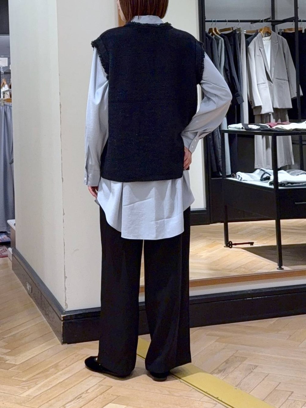 グレー系のベスト、ブラック系のスラックス、ブラック系のバレエシューズを着用したレディースの秋コーディネートの3枚目の写真