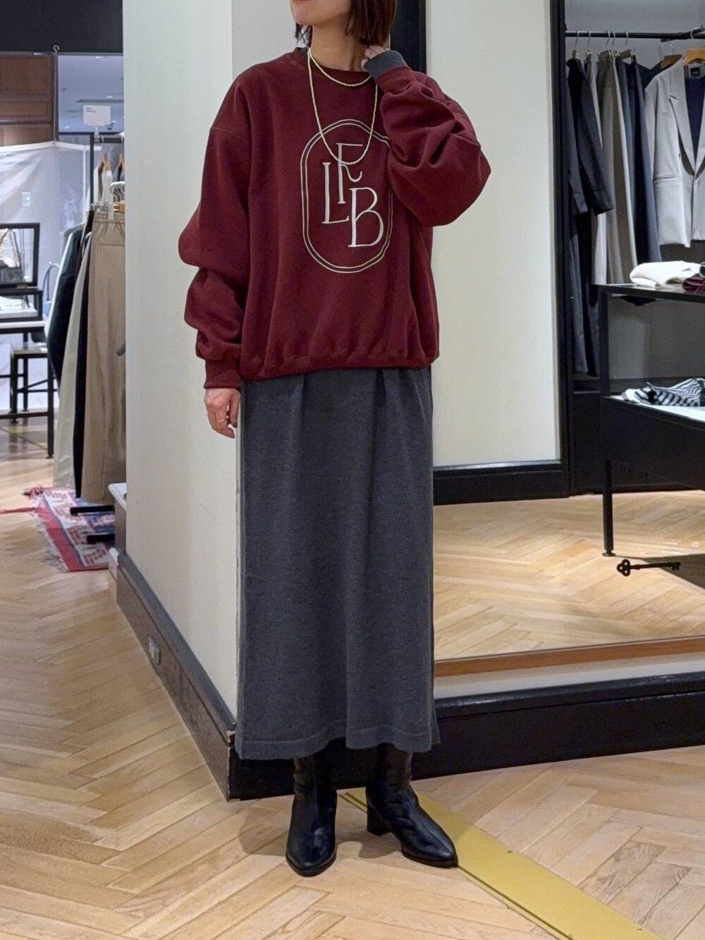 ブラック系のブーツ、ブラック系のショルダーバッグ、グレー系のワンピースを着用したレディースの秋コーディネートの5枚目の写真