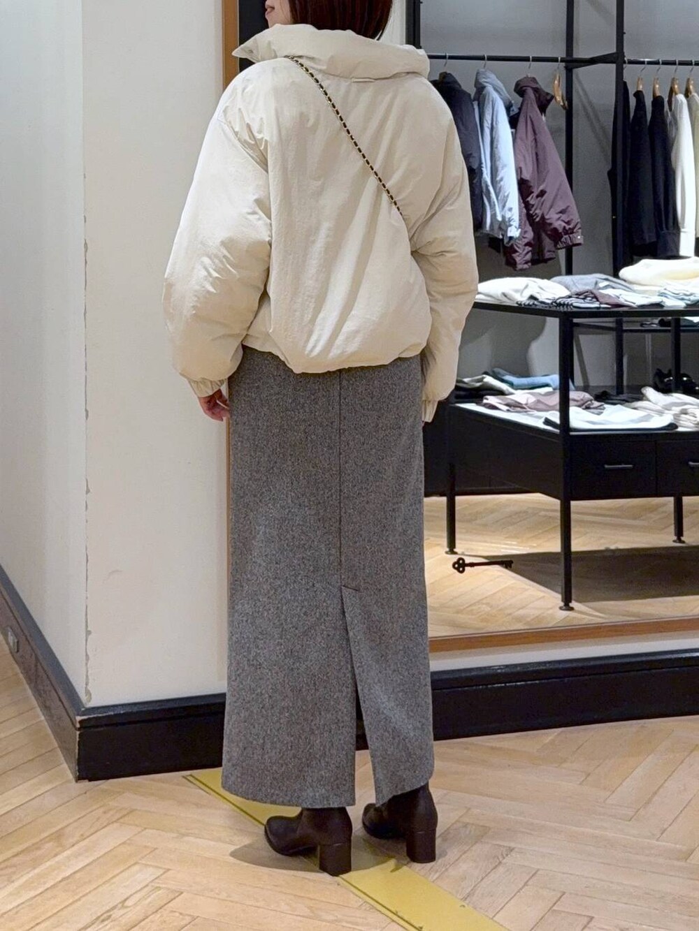 ブラウン系のブーツ、ホワイト系のブルゾン、ブラック系のスカートを着用したレディースの秋コーディネートの3枚目の写真