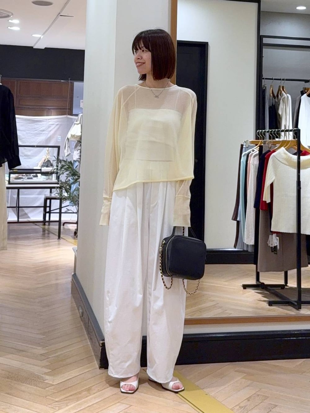 ブラック系のショルダーバッグ、ホワイト系のパンプス、ブラック系のその他パンツを着用したレディースの春コーディネートの4枚目の写真