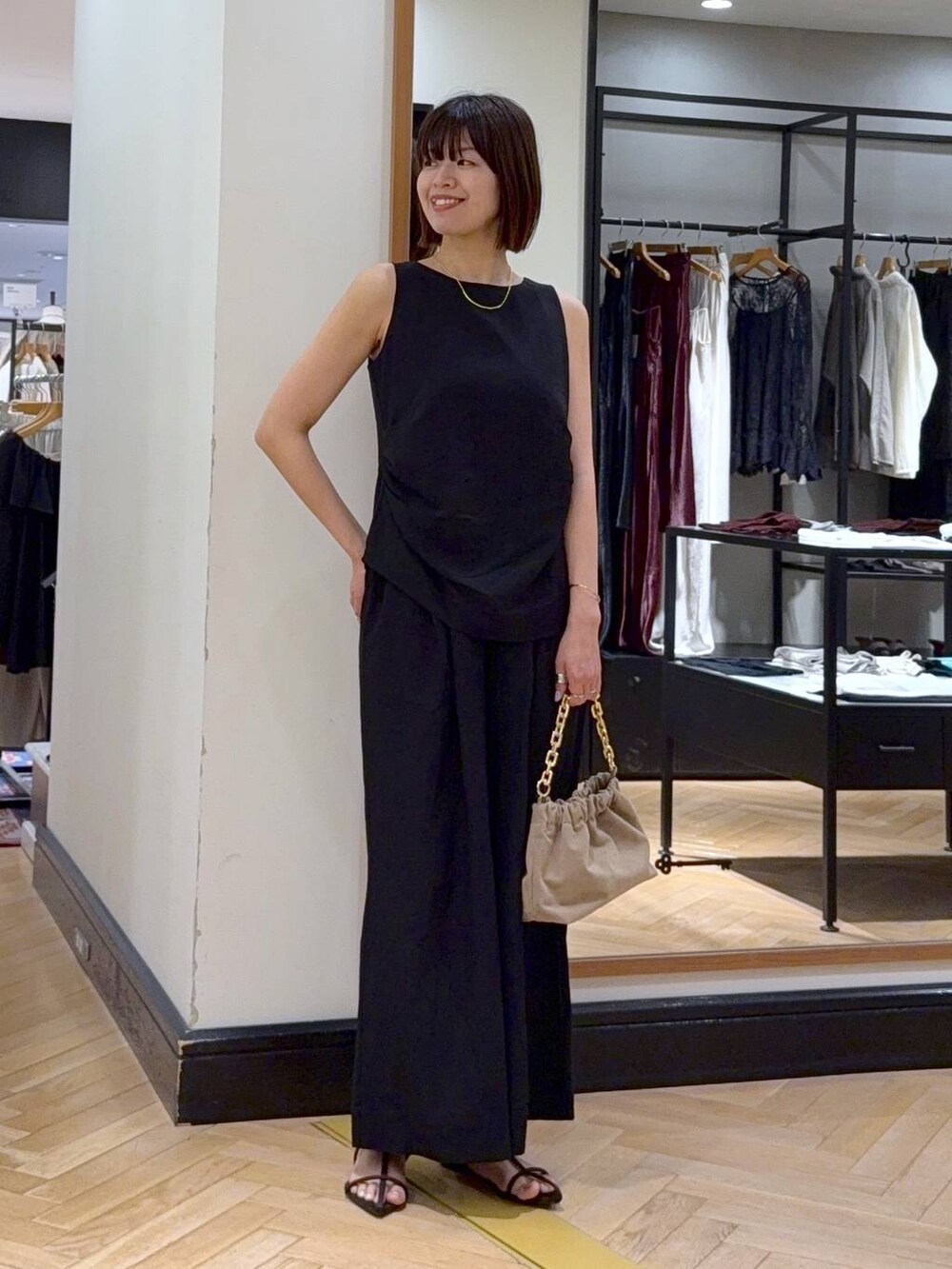 ブラウン系のサンダル、ベージュ系のショルダーバッグ、ブラック系のパンツドレスを着用したレディースの夏コーディネートの5枚目の写真