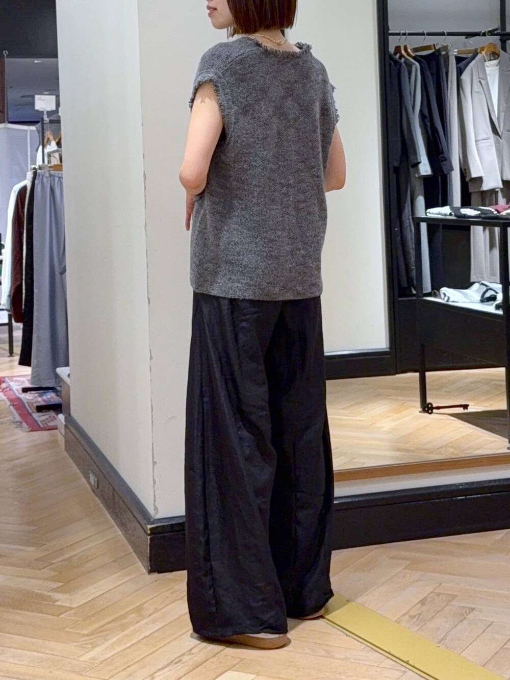 グレー系のベスト、ブラック系のその他パンツ、ブラック系のショルダーバッグを着用したレディースの秋コーディネートの3枚目の写真