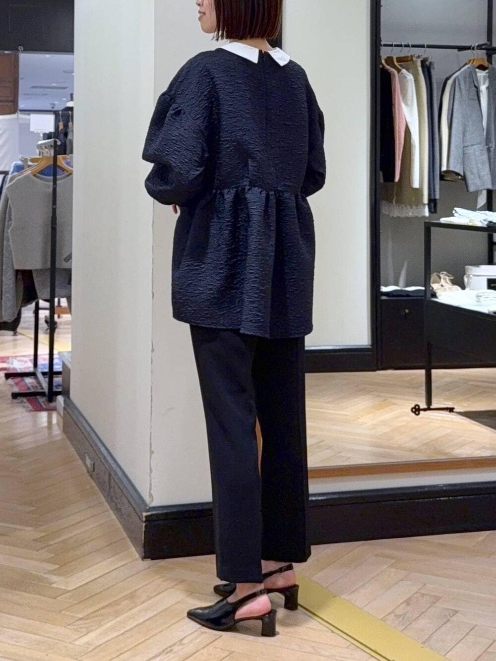 ブラック系のショルダーバッグ、ブルー系のスーツセット、ブラック系のその他シューズを着用したレディースの冬コーディネートの4枚目の写真