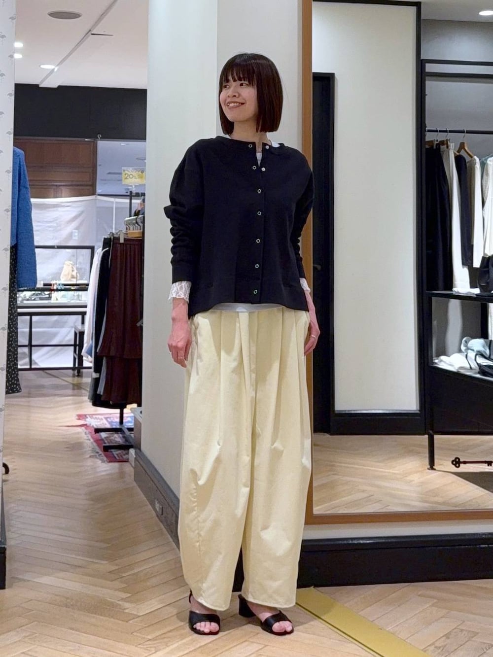 ブラック系のショルダーバッグ、ブルー系のTシャツ/カットソー、ブラック系のサンダルを着用したレディースの春コーディネートの6枚目の写真