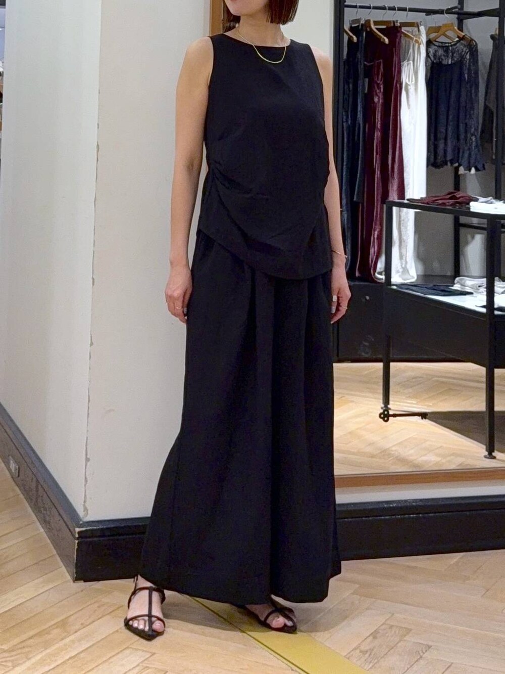 ブラウン系のサンダル、ベージュ系のショルダーバッグ、ブラック系のパンツドレスを着用したレディースの夏コーディネートの4枚目の写真