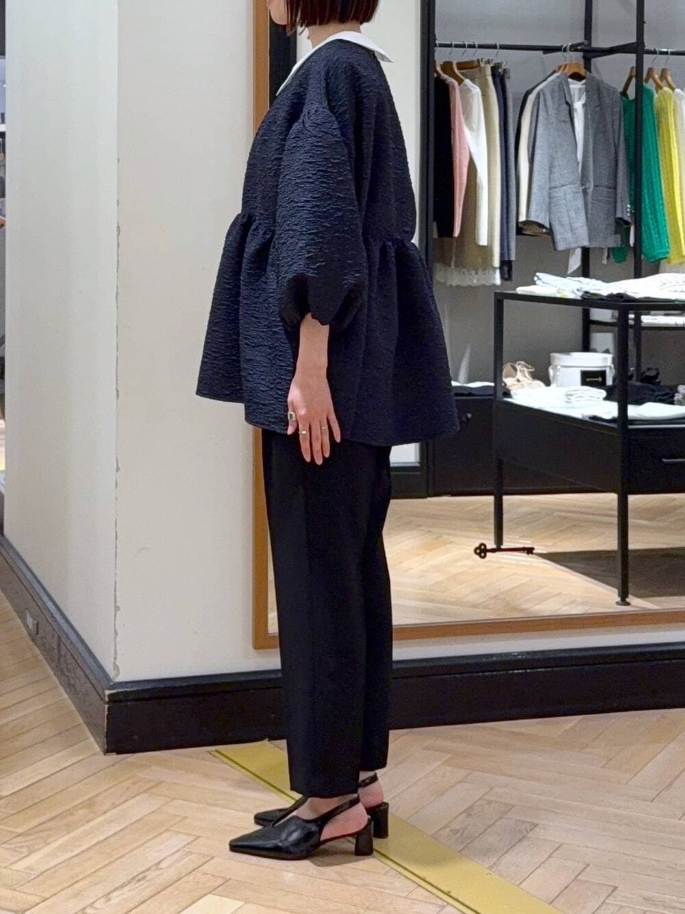 ブラック系のショルダーバッグ、ブルー系のスーツセット、ブラック系のその他シューズを着用したレディースの冬コーディネートの3枚目の写真