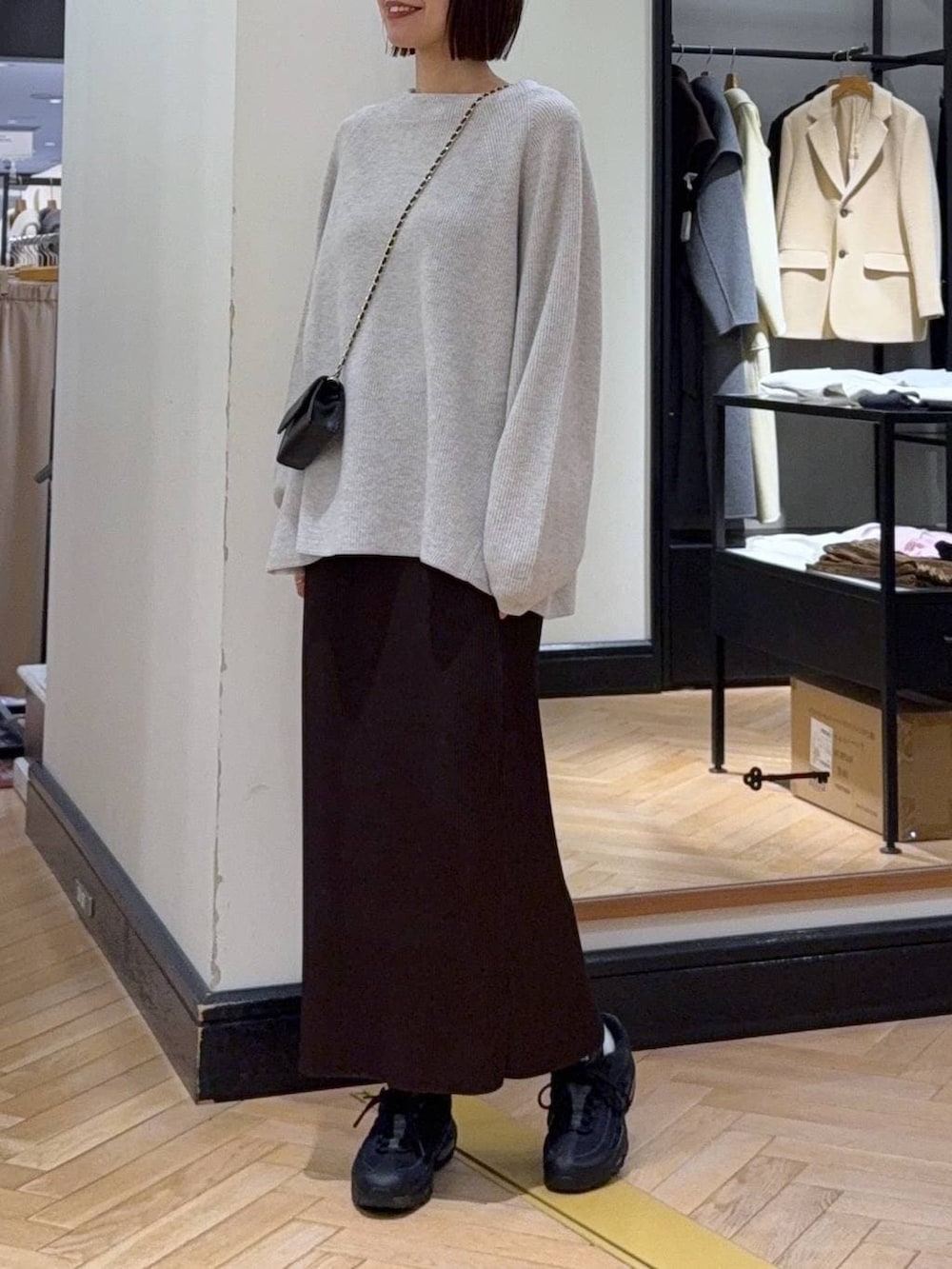 グレー系のニット/セーター、ブラウン系のスカートを着用したレディースの冬コーディネートの2枚目の写真