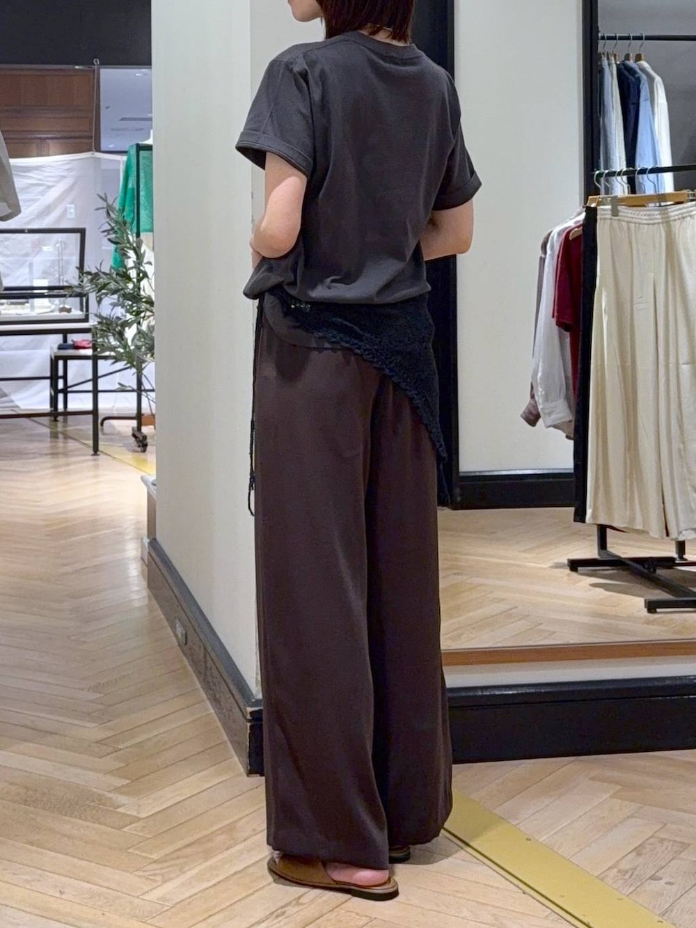 ブラウン系のスラックス、ブラック系のショルダーバッグ、グレー系のTシャツ/カットソーを着用したレディースの夏コーディネートの4枚目の写真