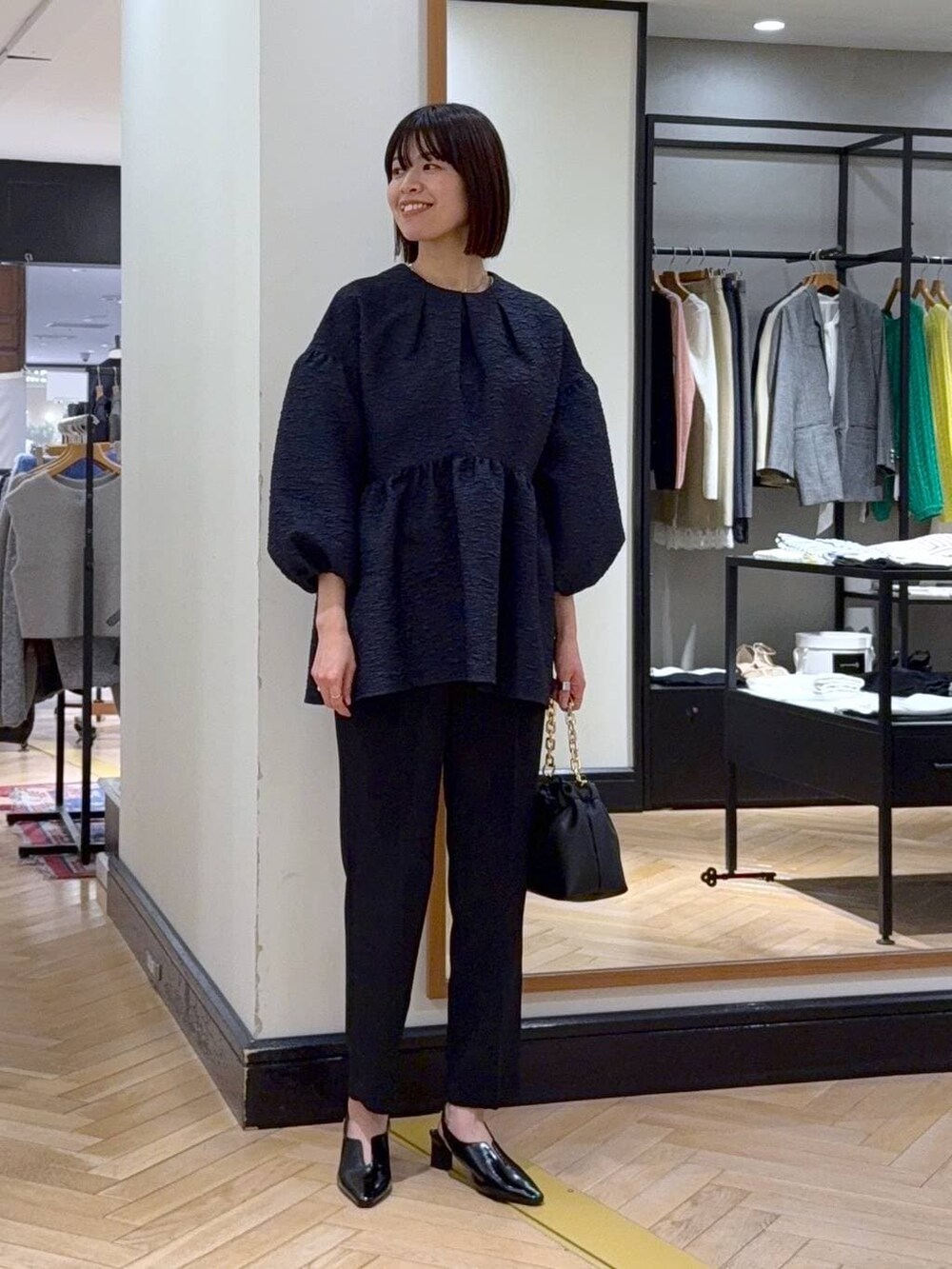 ブラック系のショルダーバッグ、ブルー系のスーツセット、ブラック系のその他シューズを着用したレディースの冬コーディネートの2枚目の写真