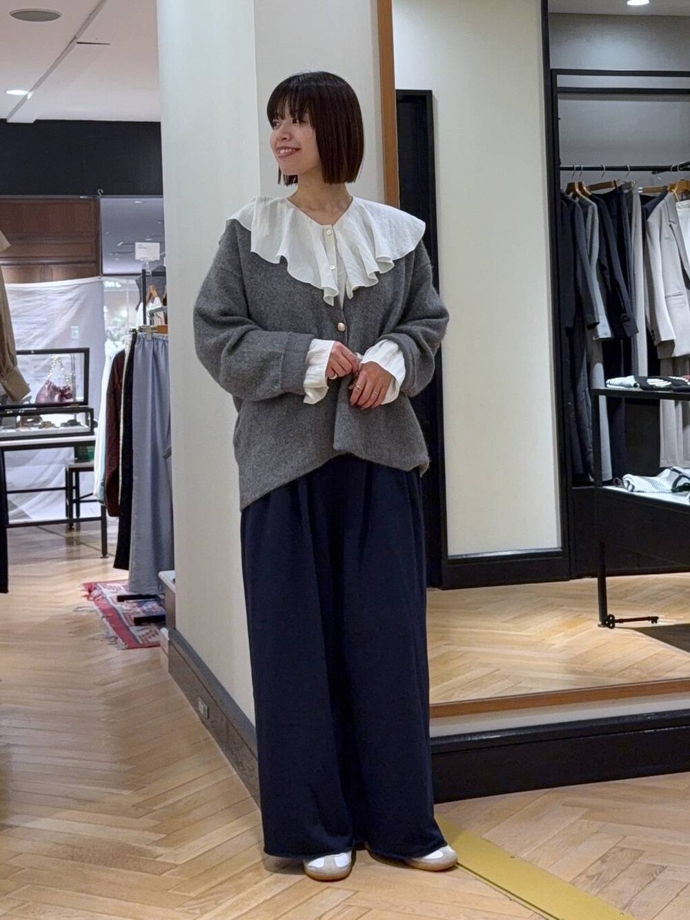 グレー系のカーディガン/ボレロ、ホワイト系のシャツ/ブラウス、ブルー系のスウェットパンツを着用したレディースの秋コーディネートの6枚目の写真