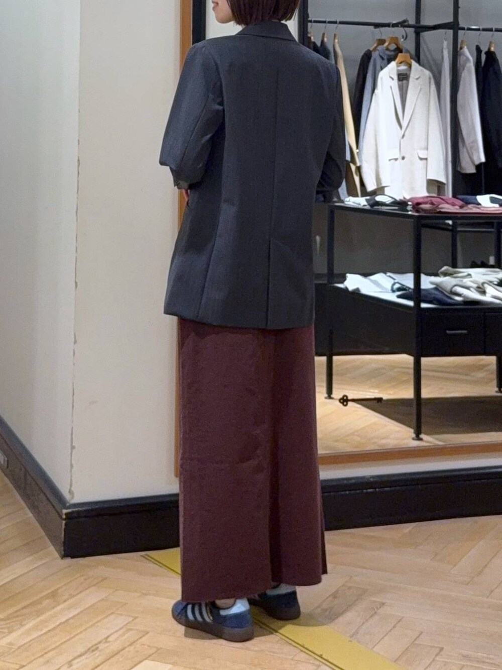 ブラック系のトートバッグ、レッド系のデニムスカート、ホワイト系のキャミソールを着用したレディースの秋コーディネートの3枚目の写真