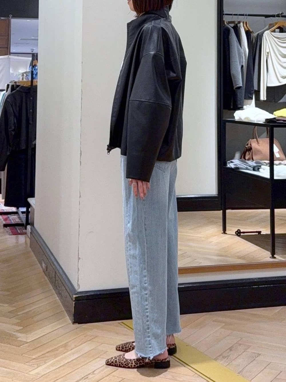 ブルー系のデニムパンツ、ブラック系のブルゾン、ブラウン系のパンプスを着用したレディースの春コーディネートの3枚目の写真