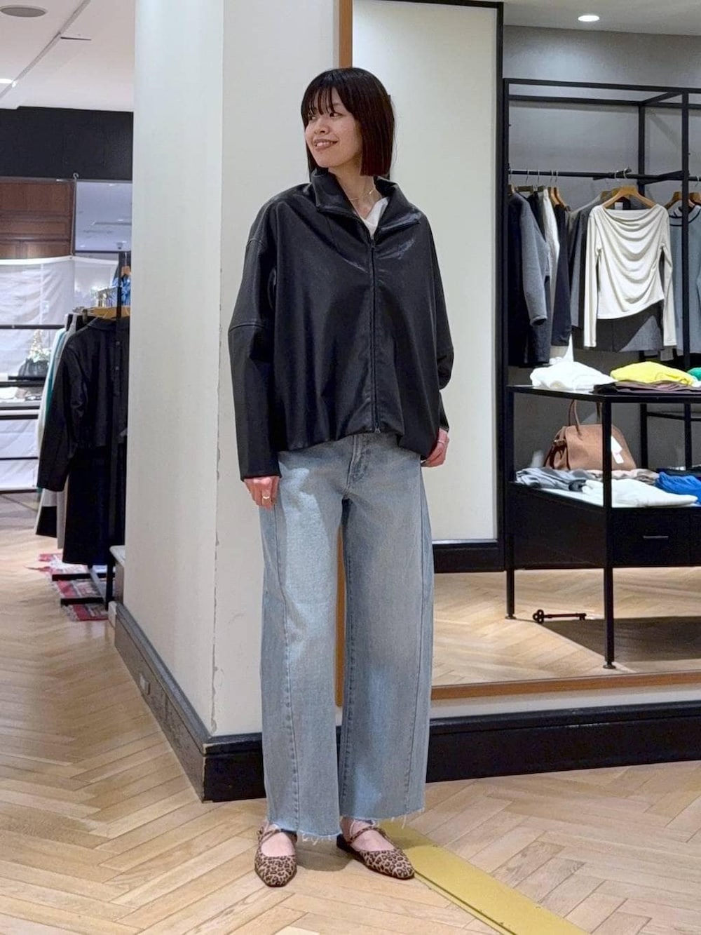 ブルー系のデニムパンツ、ブラック系のブルゾン、ブラウン系のパンプスを着用したレディースの春コーディネートの6枚目の写真