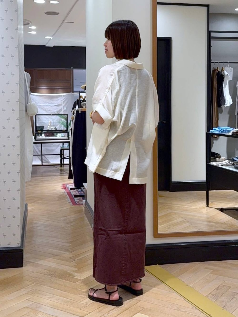 シルバー系のハンドバッグ、レッド系のワンピース、ホワイト系のサンダルを着用したレディースの夏コーディネートの3枚目の写真