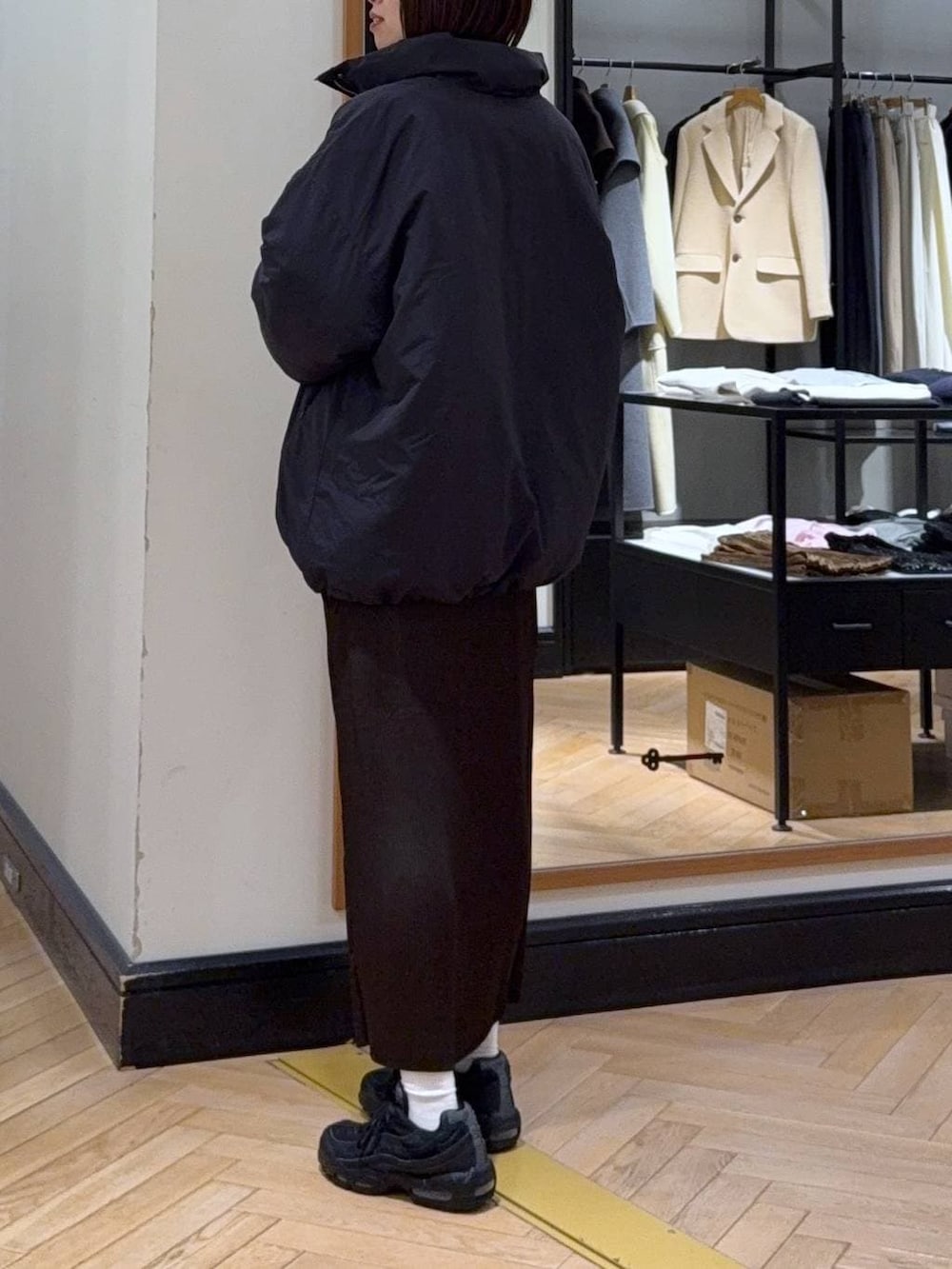 ブラック系のブルゾン、グレー系のニット/セーター、ブラウン系のスカートを着用したレディースの冬コーディネートの3枚目の写真