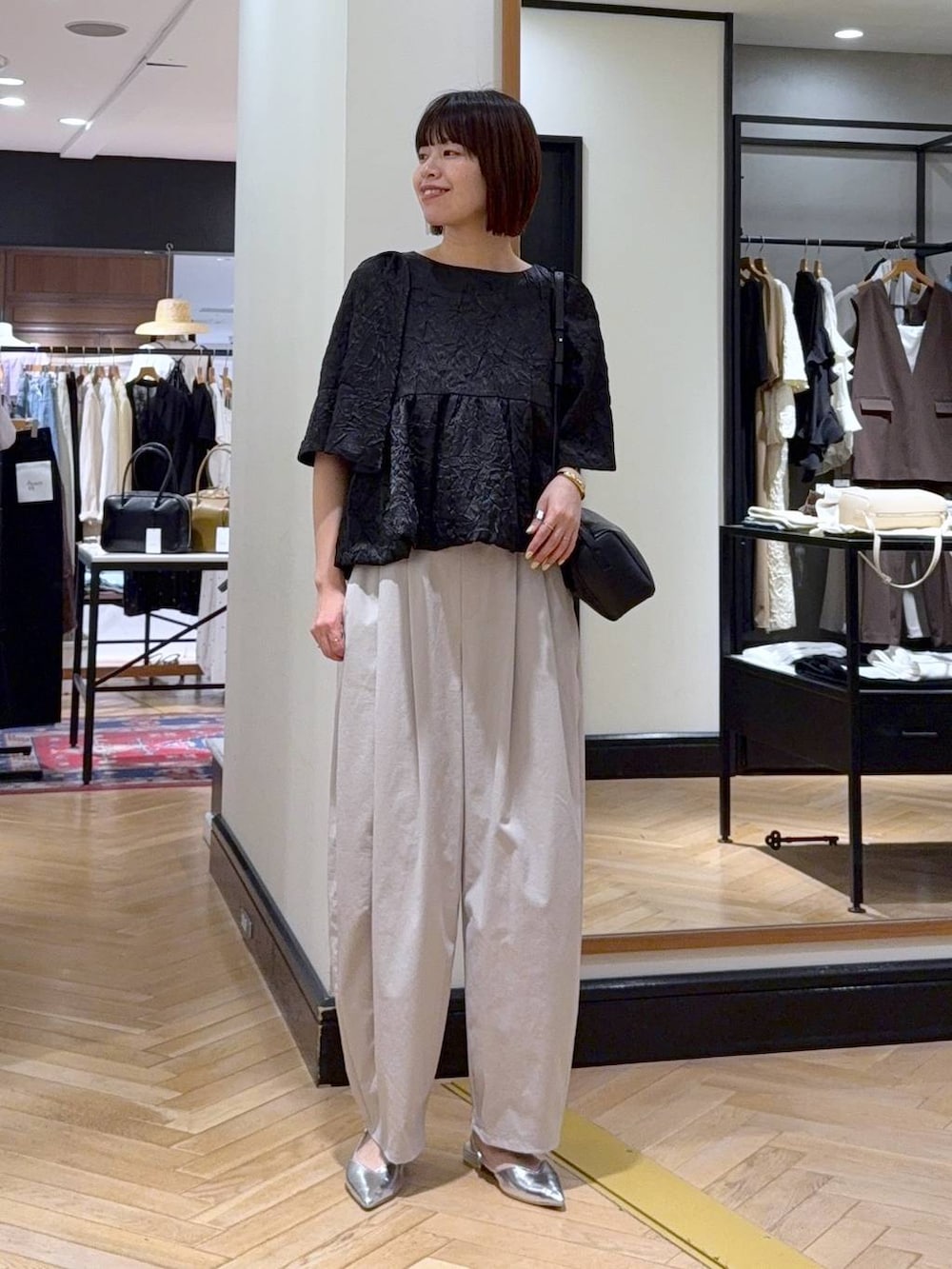 ホワイト系のハンドバッグ、シルバー系のパンプス、ブラック系のワンピースを着用したレディースの夏コーディネートの5枚目の写真