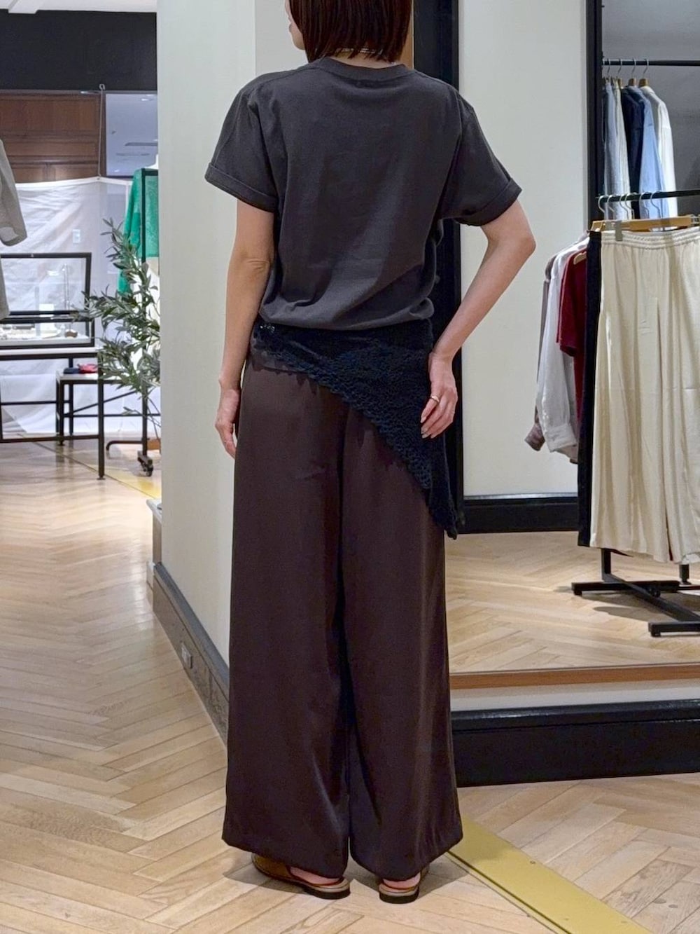 ブラウン系のスラックス、ブラック系のショルダーバッグ、グレー系のTシャツ/カットソーを着用したレディースの夏コーディネートの5枚目の写真