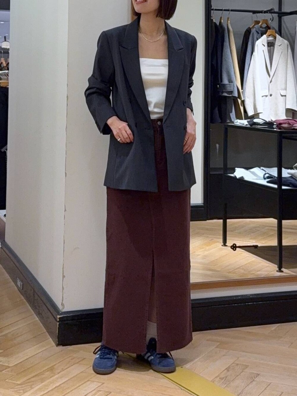 ブラック系のトートバッグ、レッド系のデニムスカート、ホワイト系のキャミソールを着用したレディースの秋コーディネートの4枚目の写真