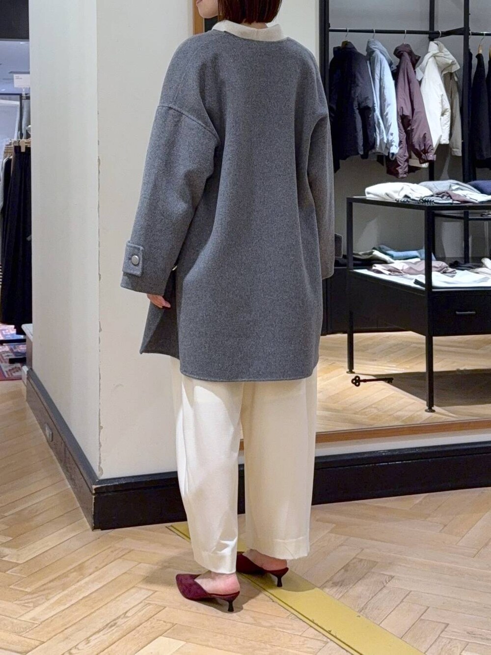 ホワイト系のスラックス、レッド系のパンプス、ブラック系のショルダーバッグを着用したレディースの秋コーディネートの5枚目の写真