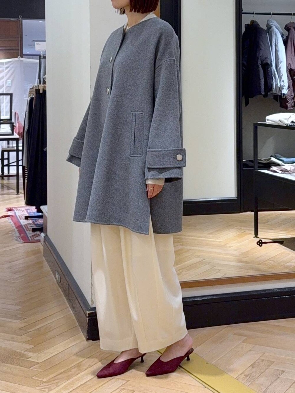 ホワイト系のスラックス、レッド系のパンプス、ブラック系のショルダーバッグを着用したレディースの秋コーディネートの3枚目の写真