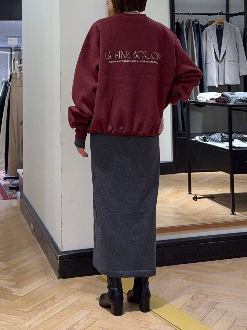 ブラック系のブーツ、ブラック系のショルダーバッグ、グレー系のワンピースを着用したレディースの秋コーディネートの4枚目の写真