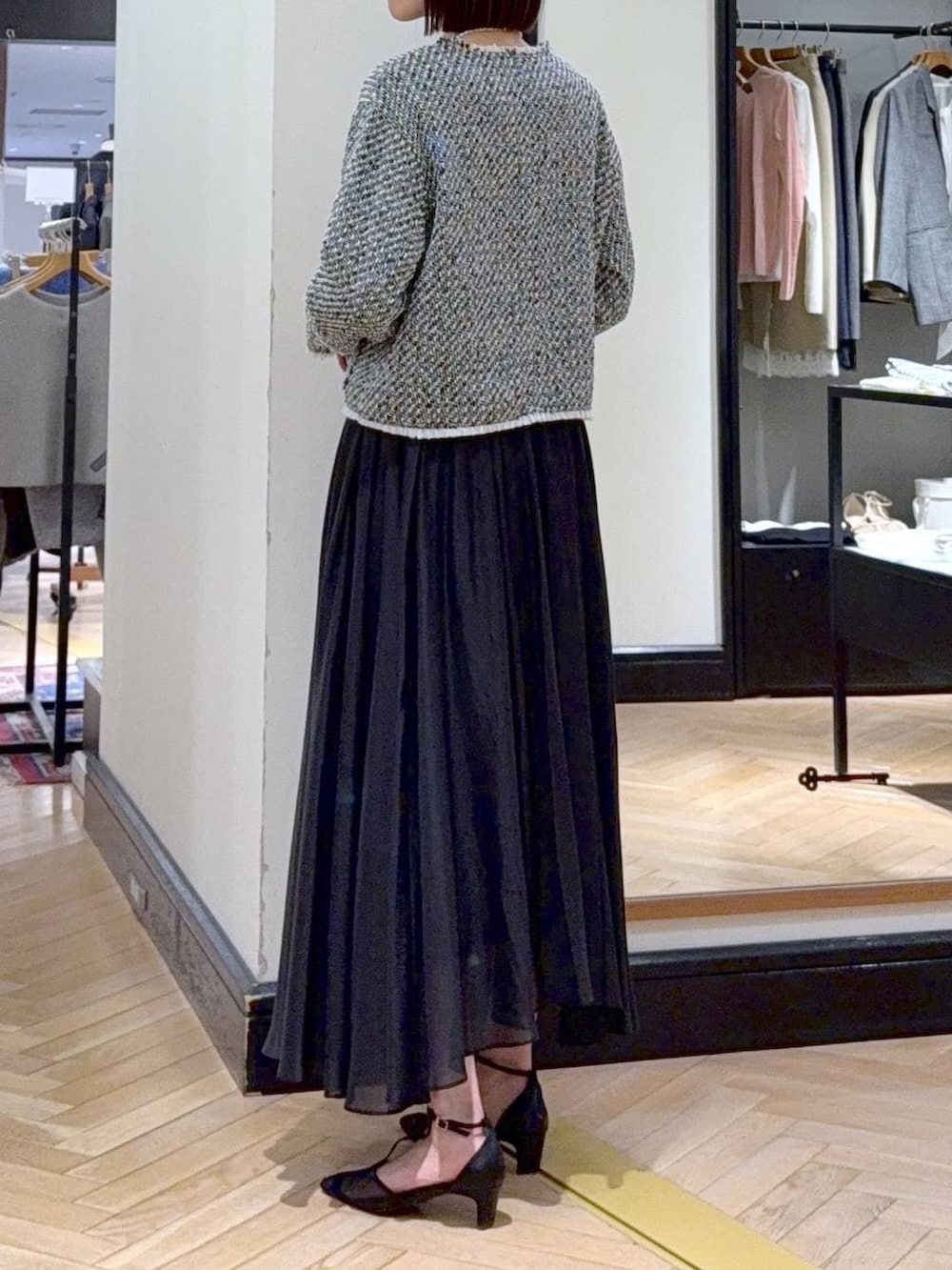 ブラック系のスカート、ブラック系のノーカラージャケット、ブラック系のパンプスを着用したレディースの冬コーディネートの4枚目の写真