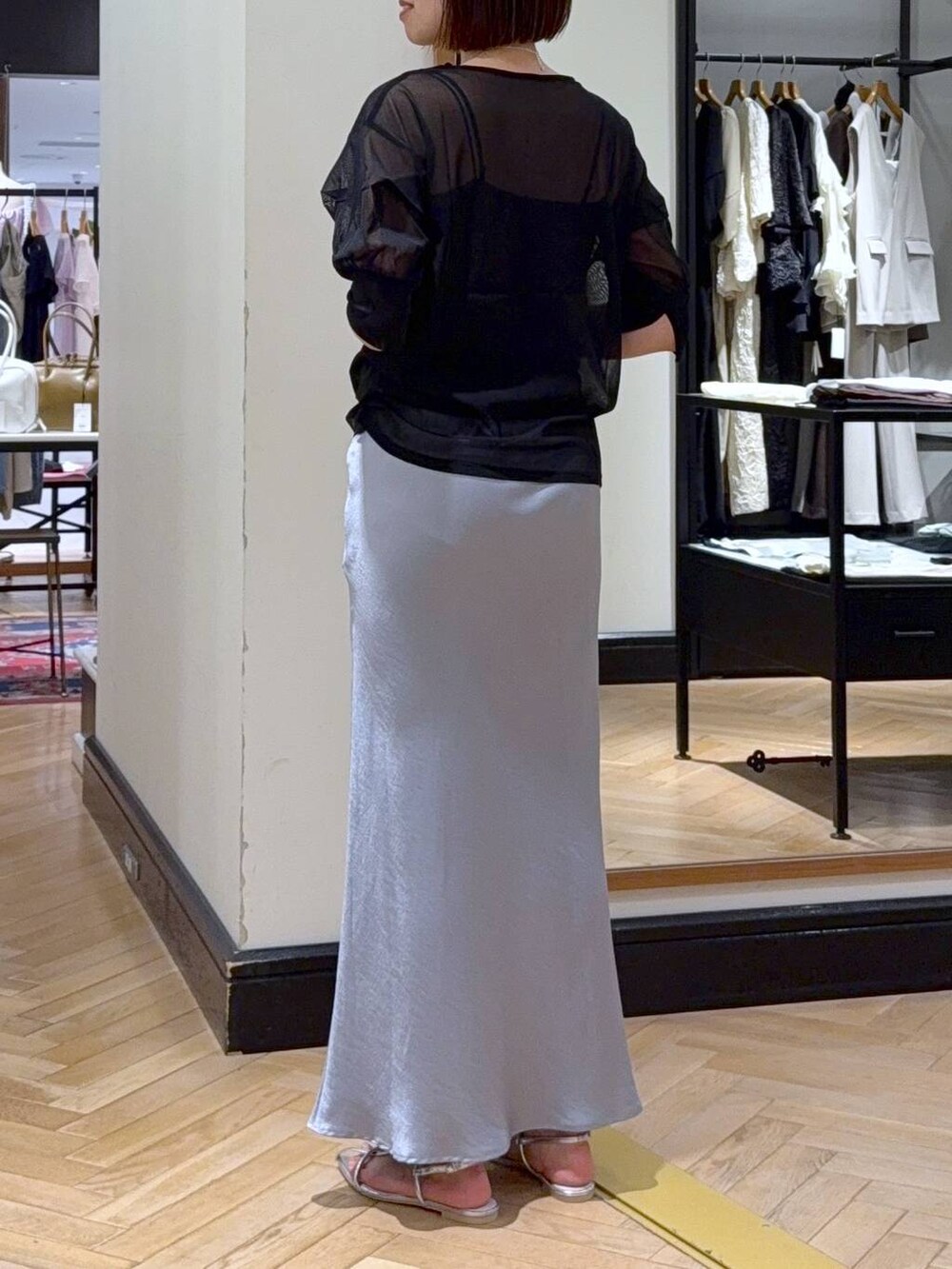 ブルー系のスカート、ブラック系のTシャツ/カットソー、ブラック系のキャミソールを着用したレディースの夏コーディネートの5枚目の写真