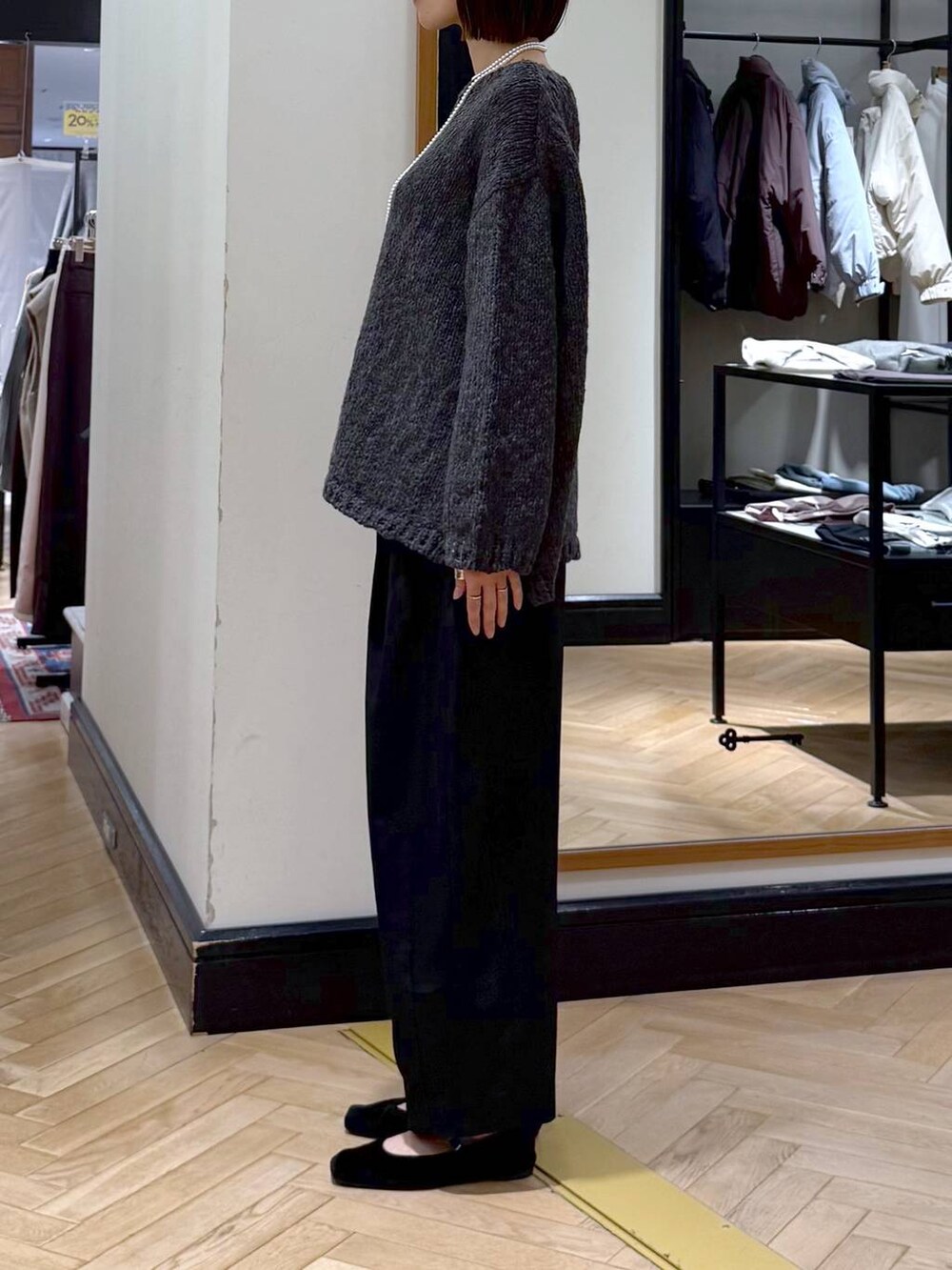 ブラック系のスラックス、グレー系のニット/セーター、ブラック系のショルダーバッグを着用したレディースの秋コーディネートの2枚目の写真