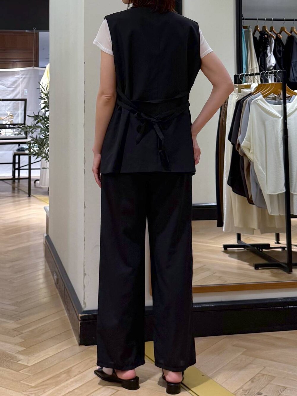 ブラウン系のハンドバッグ、ブラック系のパンプス、ブラック系のベストを着用したレディースの夏コーディネートの5枚目の写真